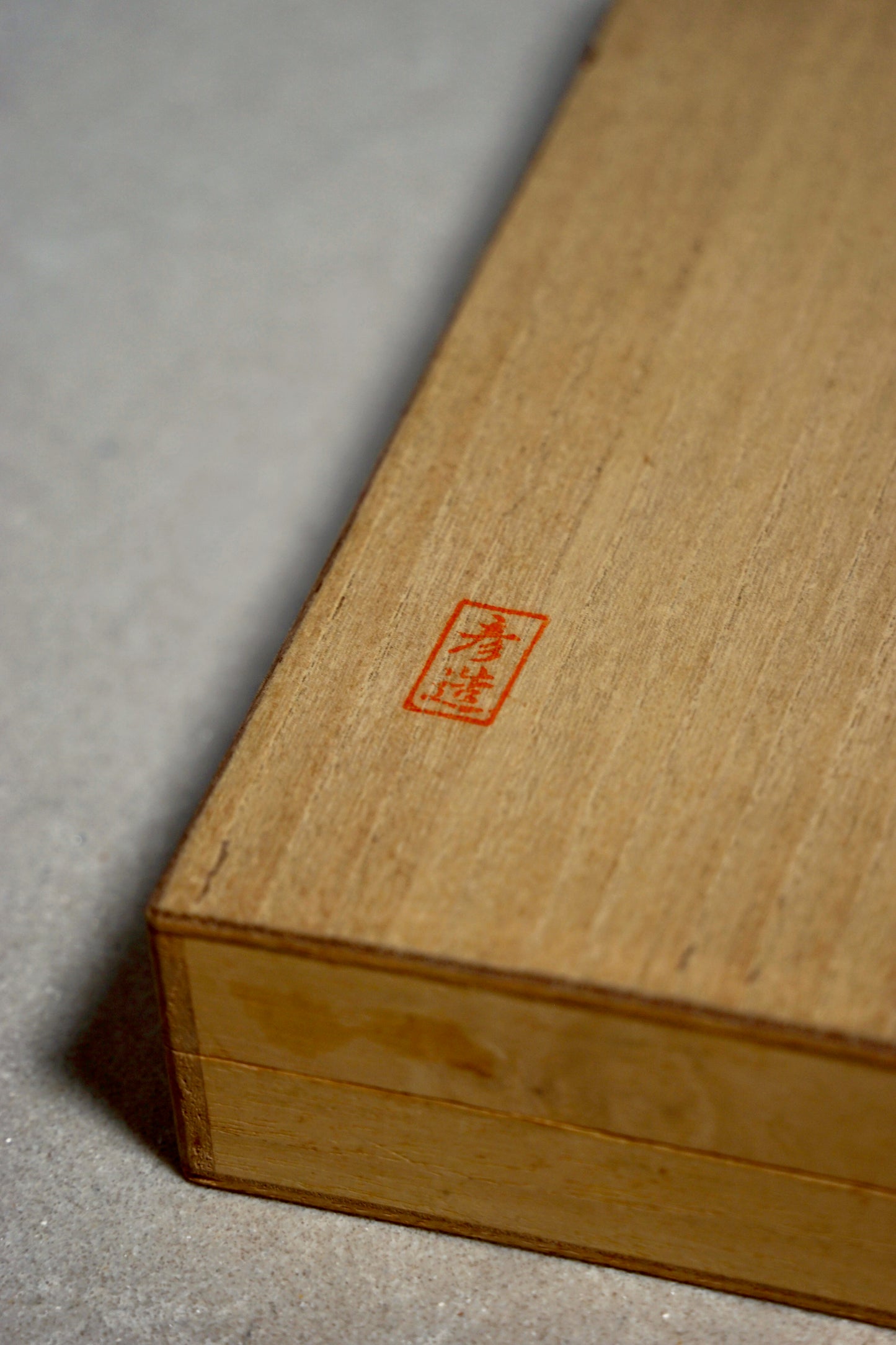 Wooden box with a red stamp on a gray surface