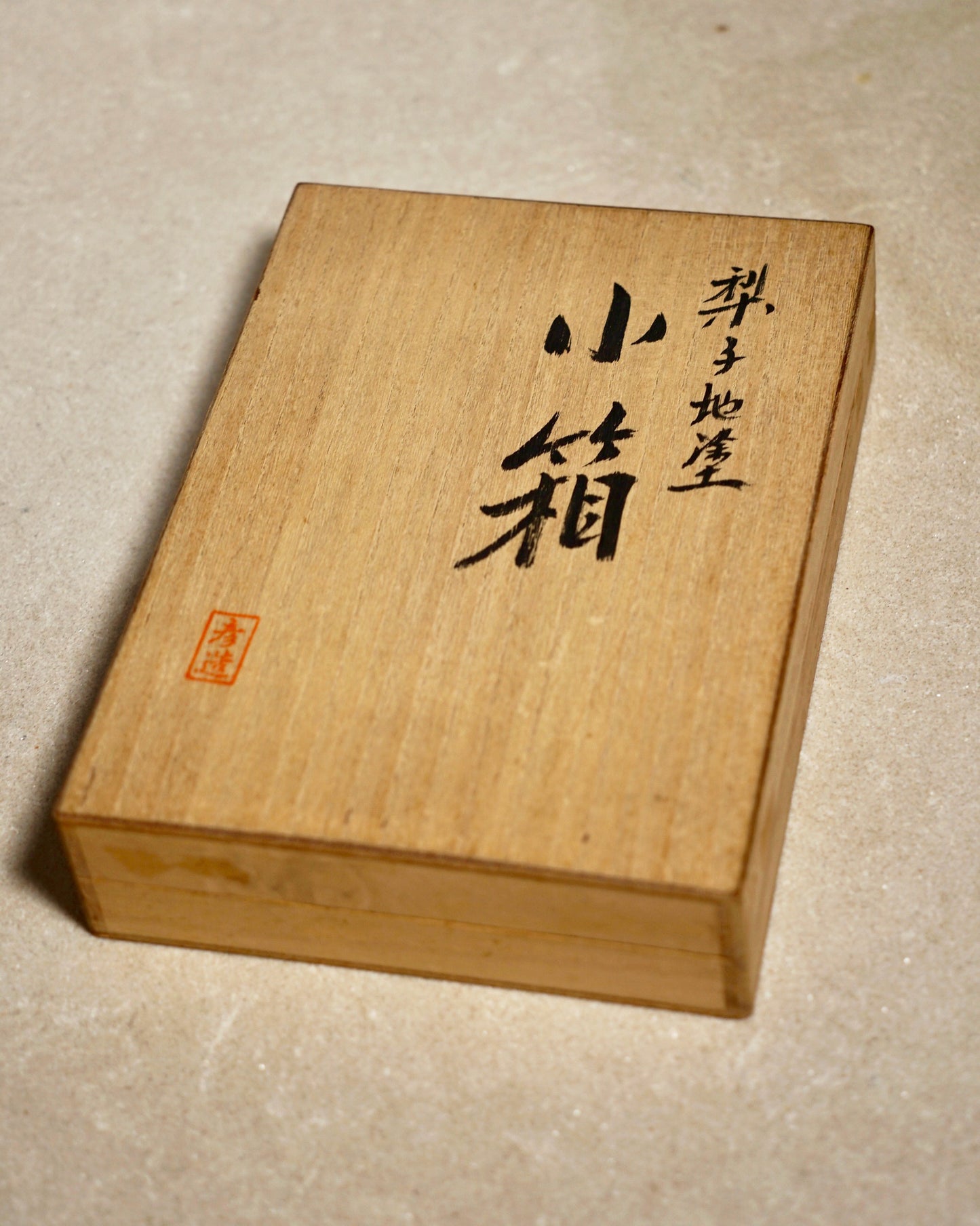 Wooden box with engraved text on a beige background
