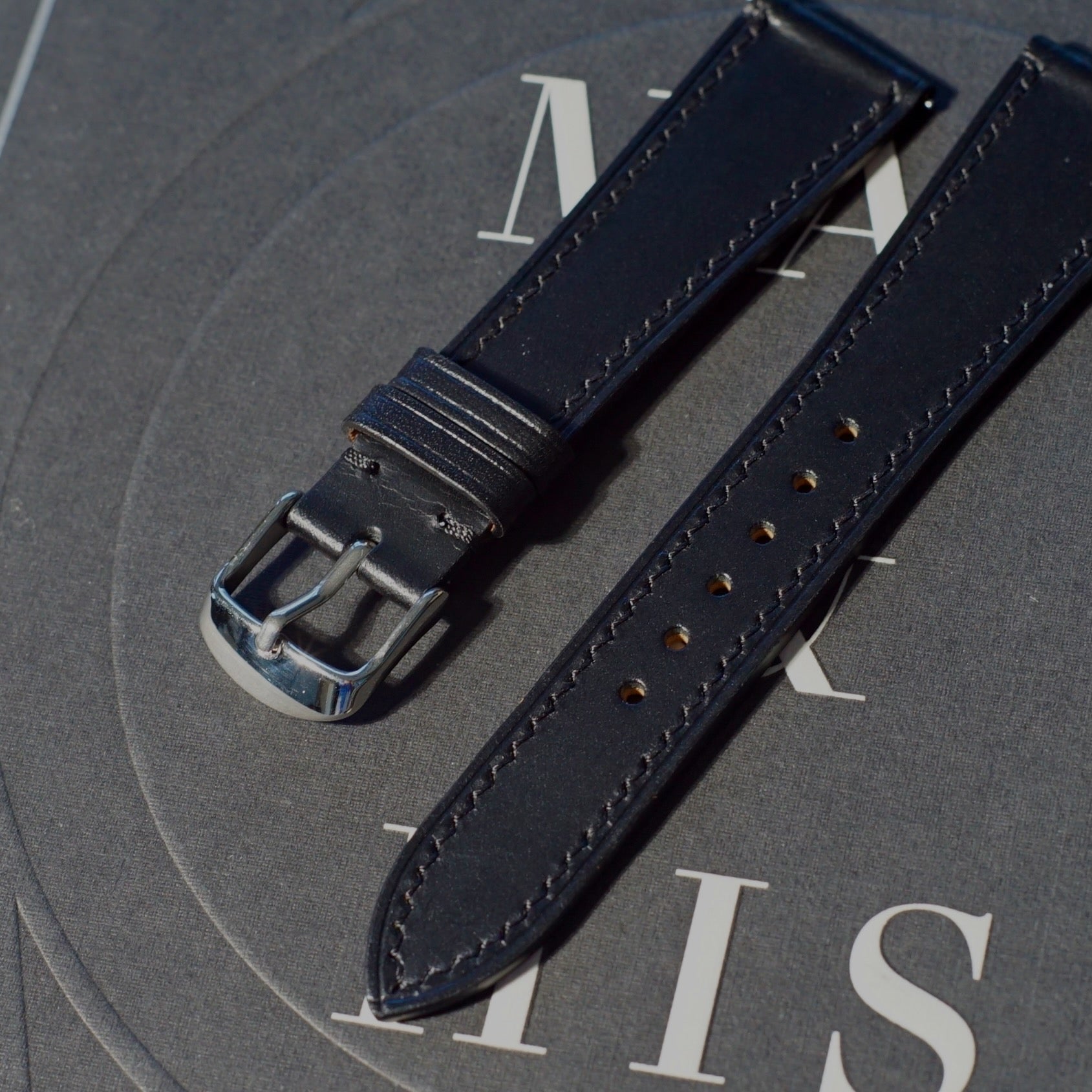 Handcrafted Black Shell Cordovan leather watch strap in 17-19mm widths. Genuine leather, small-batch production. Brushed buckle in silver or gold. Quick-release spring bar for easy installation.