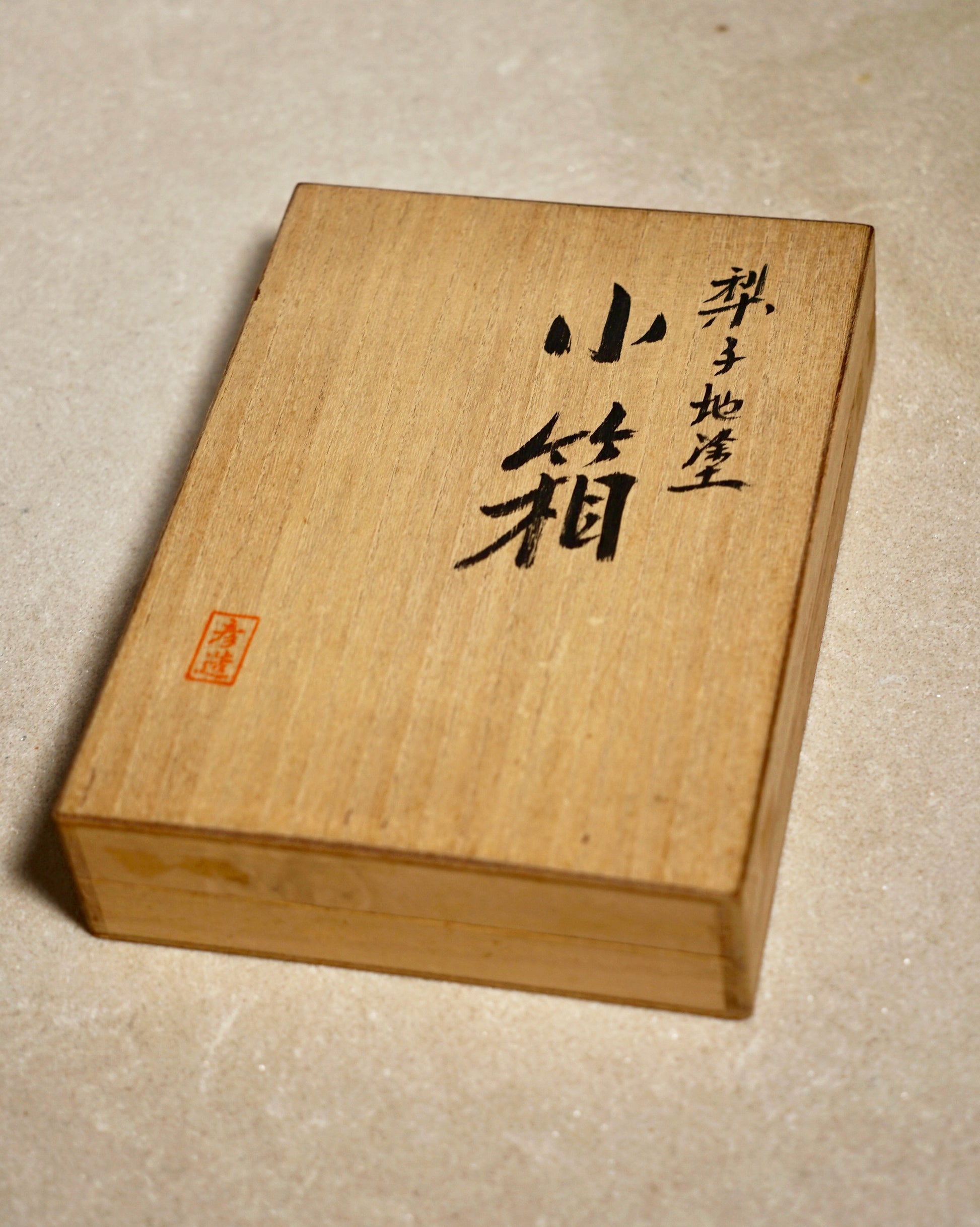 Wooden box with engraved text on a beige background