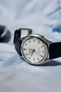 Vintage Seiko 31-7000 with a black alran strap on a textured fabric background