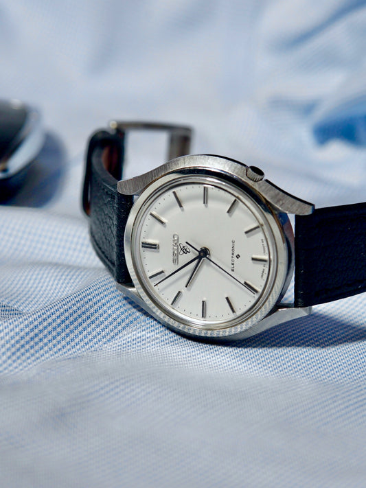 Vintage Seiko 31-7000 with a black alran strap on a textured fabric background